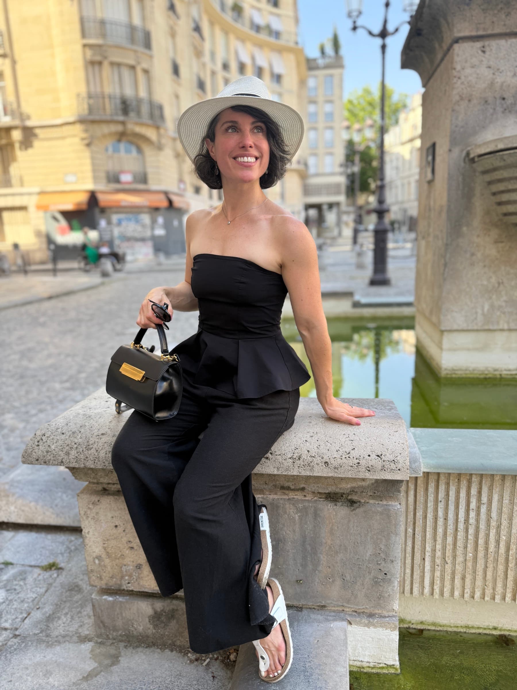 Maddy sitting by a fountain in Europe